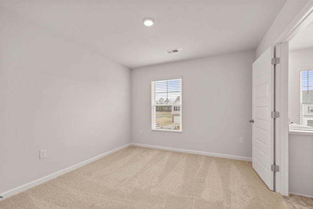 spare room featuring light colored carpet