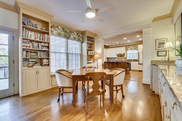 dining room featuring crown molding, ceiling fan, and light wood-type flooring