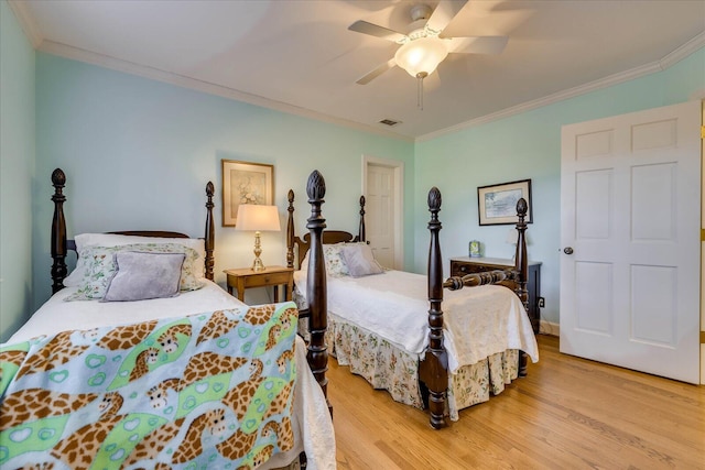 bedroom featuring ornamental molding, ceiling fan, and light wood-type flooring