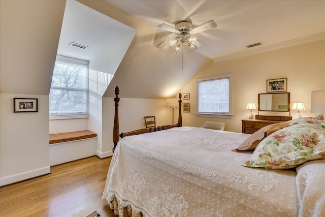 bedroom featuring multiple windows, ornamental molding, vaulted ceiling, and light hardwood / wood-style flooring