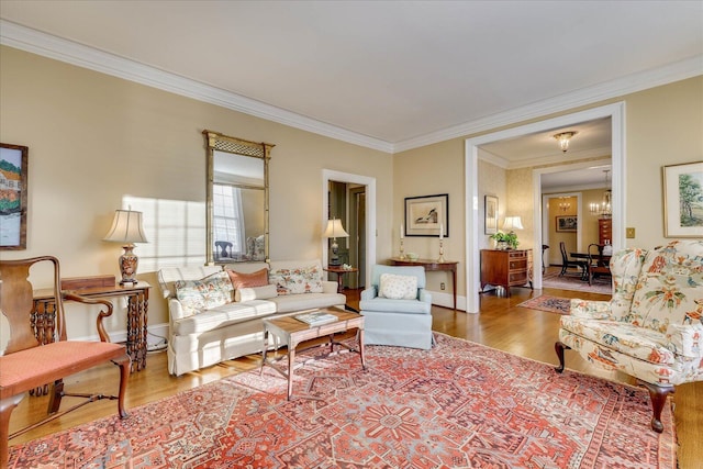 living room featuring crown molding, wood-type flooring, and a chandelier