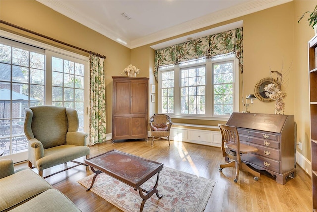 living area featuring crown molding and light hardwood / wood-style flooring