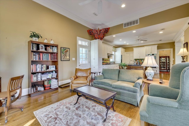 living room with crown molding, ceiling fan, and light hardwood / wood-style floors