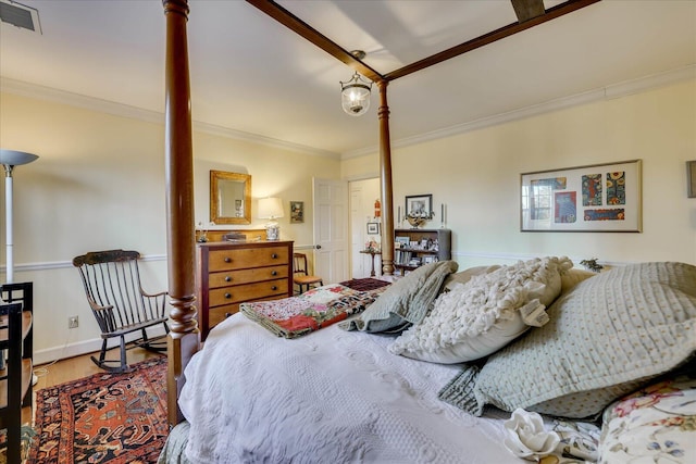 bedroom with decorative columns, crown molding, and hardwood / wood-style floors