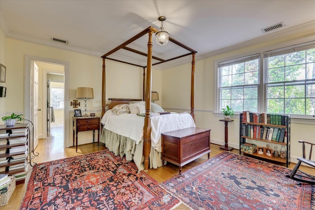 bedroom featuring multiple windows, crown molding, and light hardwood / wood-style flooring