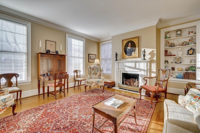 sitting room featuring hardwood / wood-style floors, built in shelves, and ornamental molding