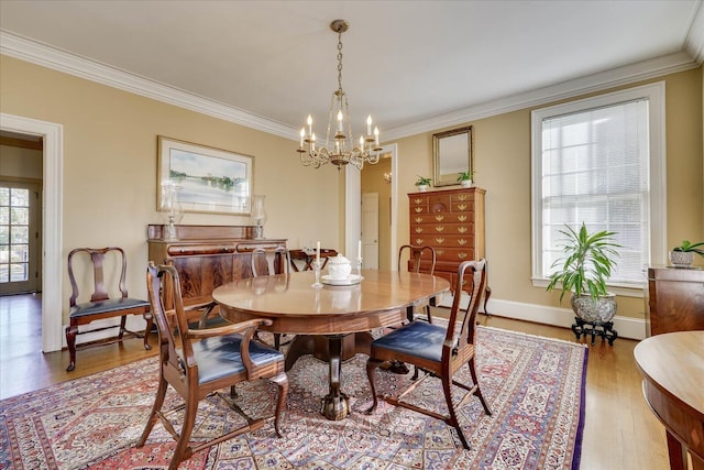 dining space with ornamental molding, light hardwood / wood-style floors, and a notable chandelier