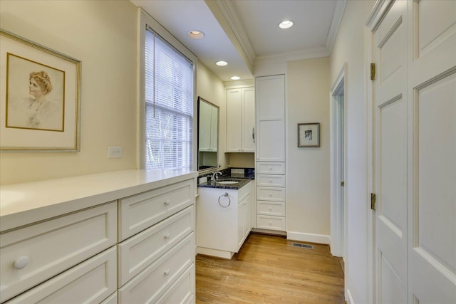 interior space featuring crown molding, sink, and hardwood / wood-style floors