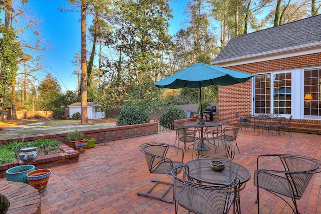 view of patio featuring an outdoor fire pit and a shed