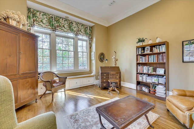 sitting room with ornamental molding and light wood-type flooring