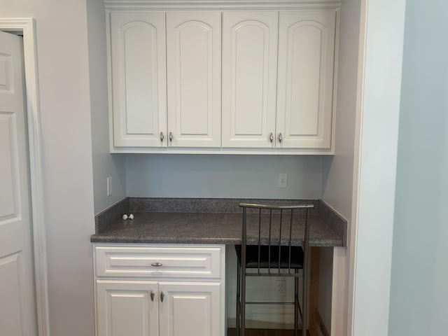 902 Patriots Pt, Mccormick, SC 29835 - kitchen with dark countertops, white cabinets, and built in desk