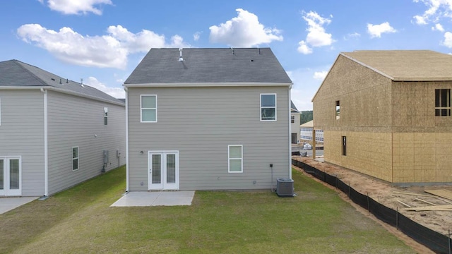 rear view of house featuring a lawn, french doors, and a patio