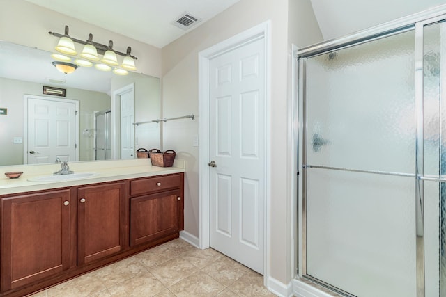 bathroom featuring tile patterned flooring, vanity, and a shower with door