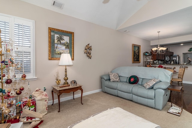 carpeted living room featuring lofted ceiling and a notable chandelier