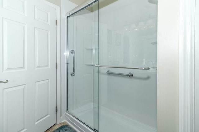 bathroom with tile patterned floors and a shower with shower door