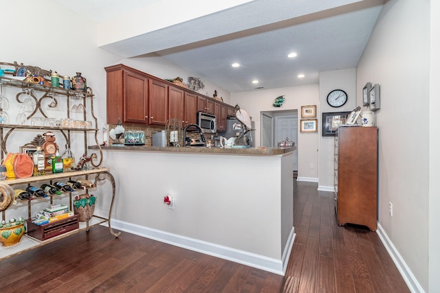 kitchen with tasteful backsplash, kitchen peninsula, and dark hardwood / wood-style flooring