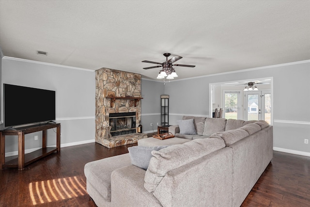 living room featuring ceiling fan, dark hardwood / wood-style floors, crown molding, a textured ceiling, and a fireplace