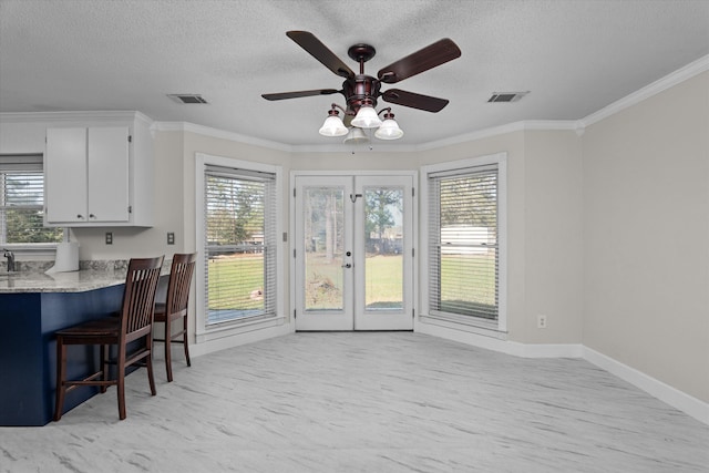 dining area with ceiling fan, french doors, and ornamental molding