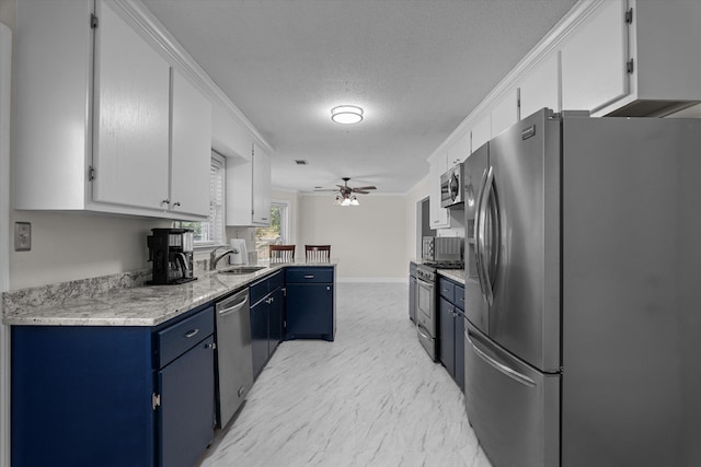 kitchen featuring appliances with stainless steel finishes, a textured ceiling, blue cabinets, ceiling fan, and white cabinetry