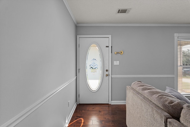 entrance foyer with dark wood-type flooring, a healthy amount of sunlight, and ornamental molding