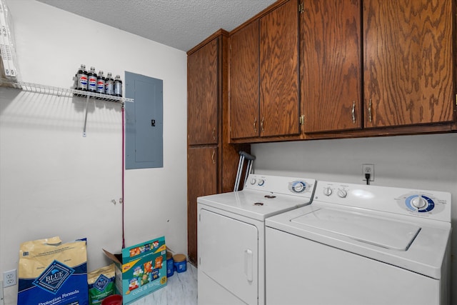 washroom featuring washer and clothes dryer, cabinets, a textured ceiling, and electric panel