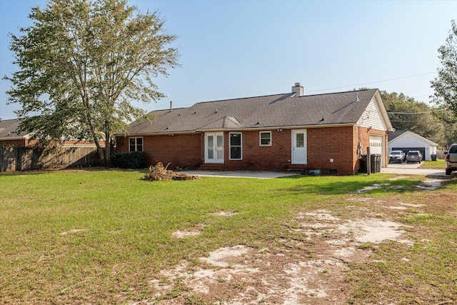 rear view of house with a garage and a yard