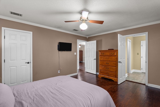 bedroom with ceiling fan, crown molding, dark wood-type flooring, and a textured ceiling