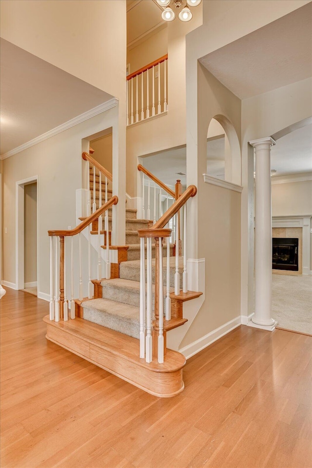 1123 Blackfoot Dr, Evans, GA 30809 - staircase with crown molding, wood finished floors, decorative columns, and a tiled fireplace