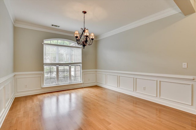 1123 Blackfoot Dr, Evans, GA 30809 - unfurnished room featuring a chandelier, ornamental molding, light wood-type flooring, wainscoting, and a decorative wall