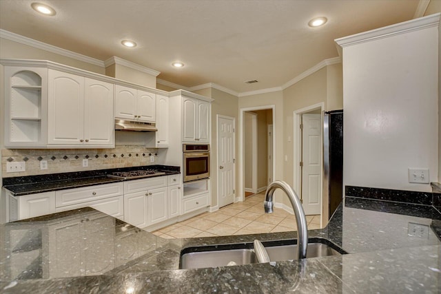 1123 Blackfoot Dr, Evans, GA 30809 - kitchen with appliances with stainless steel finishes, under cabinet range hood, backsplash, crown molding, and white cabinetry