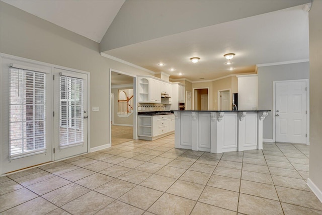 1123 Blackfoot Dr, Evans, GA 30809 - kitchen with open shelves, dark countertops, light tile patterned floors, a breakfast bar, and crown molding