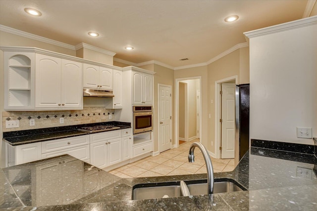1123 Blackfoot Dr, Evans, GA 30809 - kitchen featuring appliances with stainless steel finishes, under cabinet range hood, a warming drawer, tasteful backsplash, and white cabinets