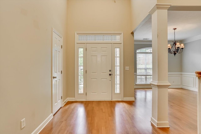1123 Blackfoot Dr, Evans, GA 30809 - entrance foyer with decorative columns, light wood-style floors, crown molding, a chandelier, and a high ceiling