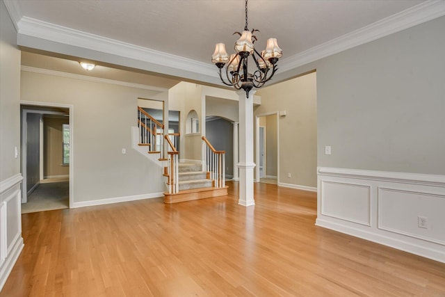 1123 Blackfoot Dr, Evans, GA 30809 - spare room featuring crown molding, arched walkways, light wood-style flooring, a chandelier, and stairway