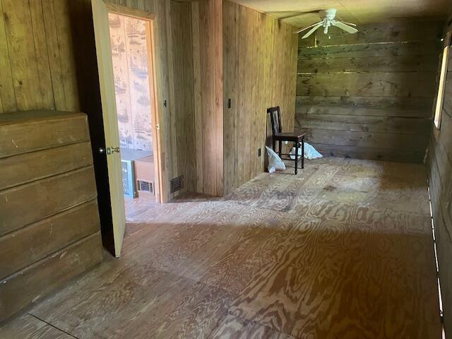 miscellaneous room featuring wood walls and ceiling fan