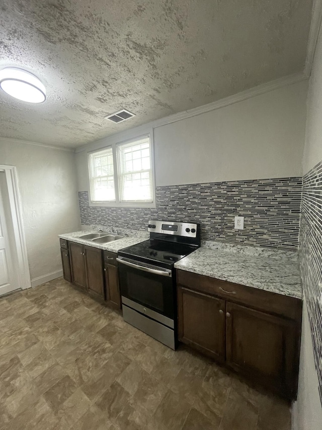 kitchen with stainless steel range with electric cooktop, sink, a textured ceiling, tasteful backsplash, and dark brown cabinets