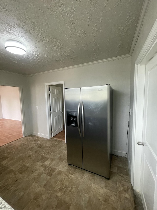 kitchen with stainless steel refrigerator with ice dispenser, a textured ceiling, and crown molding