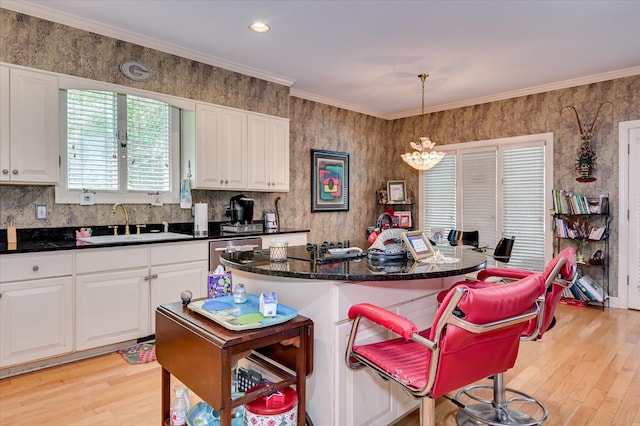 3725 Wexford Dr, Martinez, GA 30907 - kitchen featuring light wood-type flooring, white cabinetry, a breakfast bar area, a center island, and crown molding