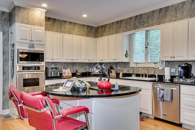 3725 Wexford Dr, Martinez, GA 30907 - kitchen with stainless steel appliances, white cabinets, light wood-style flooring, crown molding, and a kitchen island