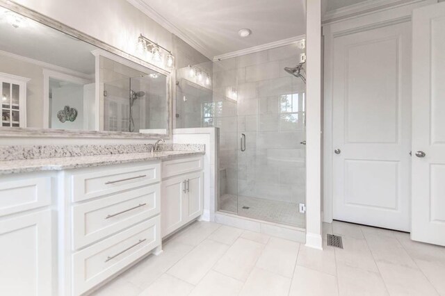 bathroom with tile patterned floors, crown molding, vanity, and walk in shower