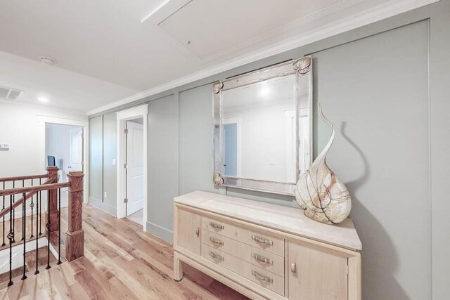 corridor featuring ornamental molding and light hardwood / wood-style flooring