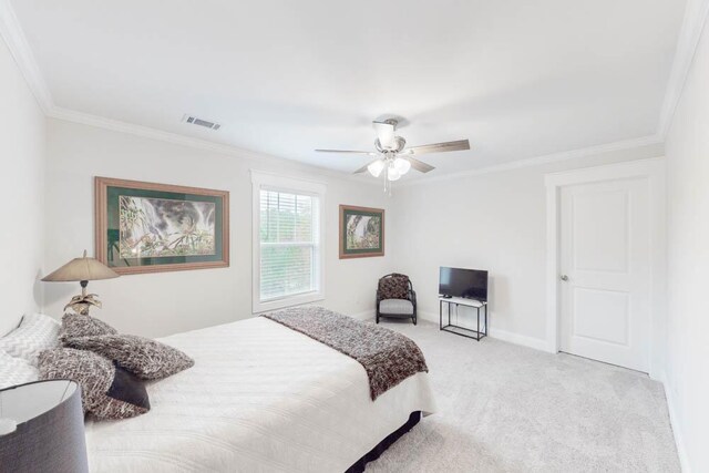 carpeted bedroom featuring ceiling fan and crown molding