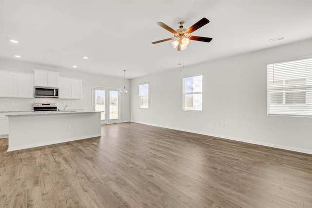 unfurnished living room featuring ceiling fan and light wood-type flooring