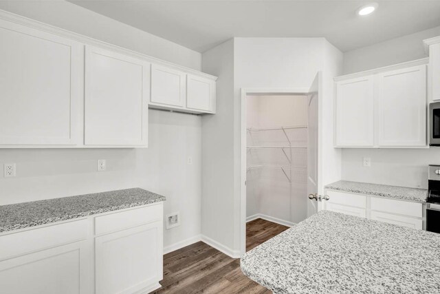 kitchen with light stone countertops, white cabinetry, and stainless steel appliances