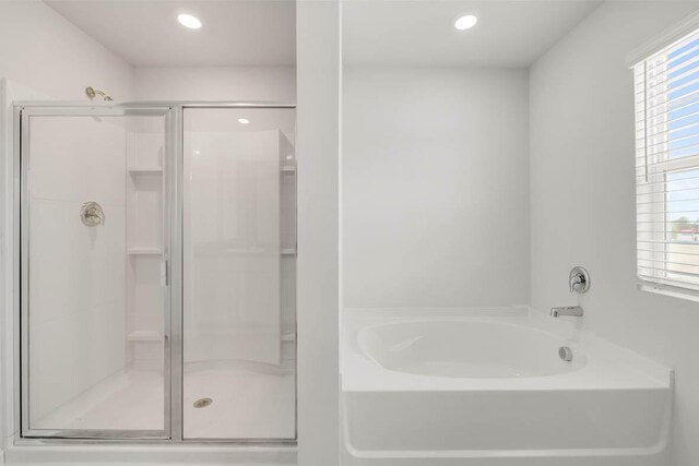 bathroom featuring shower with separate bathtub