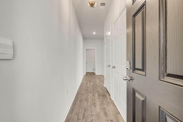 corridor with light hardwood / wood-style floors