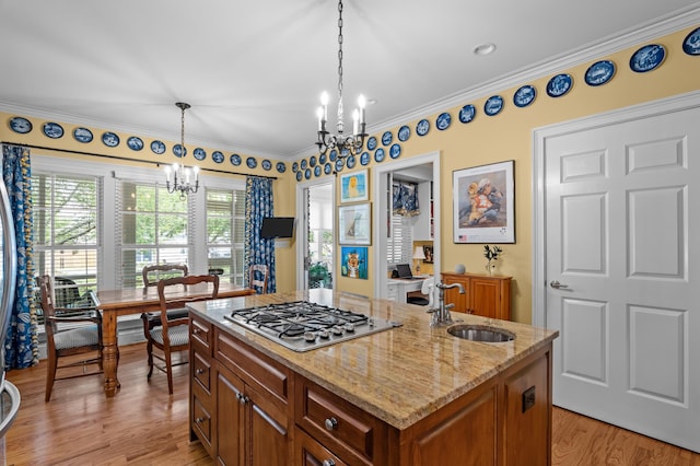 1201 Reid Rd, Augusta, GA 30909 - kitchen featuring stainless steel gas cooktop, a sink, a chandelier, light wood-style floors, and pendant lighting