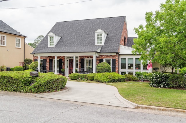 1201 Reid Rd, Augusta, GA 30909 - new england style home with a front yard, a shingled roof, covered porch, and brick siding