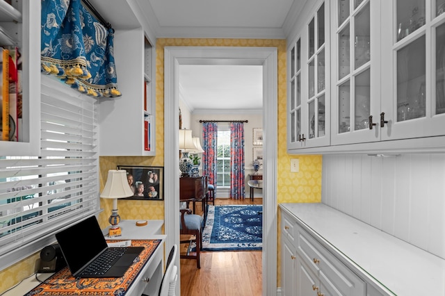 1201 Reid Rd, Augusta, GA 30909 - kitchen with glass insert cabinets, crown molding, light wood-style flooring, white cabinetry, and light countertops