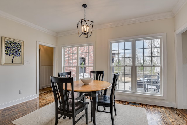 dining area with a chandelier, dark hardwood / wood-style flooring, a wealth of natural light, and crown molding